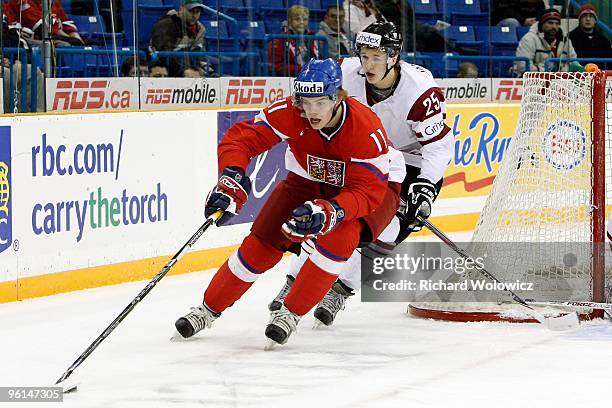 Andrej Nestrasil of Team Czech Republic skates with the puck while being chased by Martins Jakovlevs of Team Latvia during the 2010 IIHF World Junior...