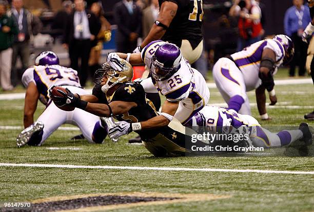 Pierre Thomas of the New Orleans Saints scores a 3-yard rushing touchdown in the third quarter against Tyrell Johnson and Madieu Williams of the...