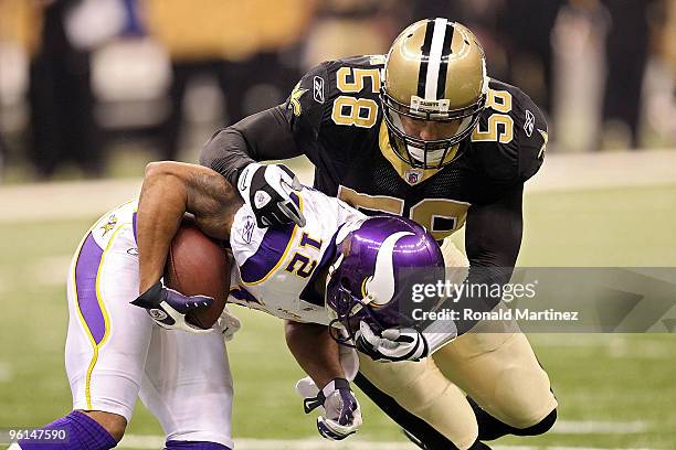 Scott Shanle of the New Orleans Saints tackles Percy Harvin of the Minnesota Vikings during the NFC Championship Game at the Louisana Superdome on...