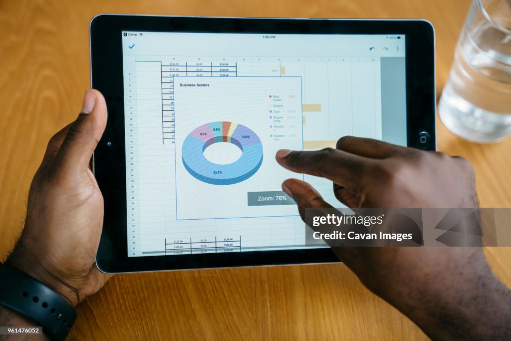Cropped image of businessman using tablet computer at table
