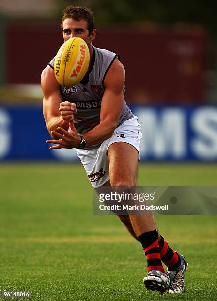 Jobe Watson captain of the Bombers handballs to a teammate during an Essendon Bombers AFL training session at Windy Hill on January 25, 2010 in...