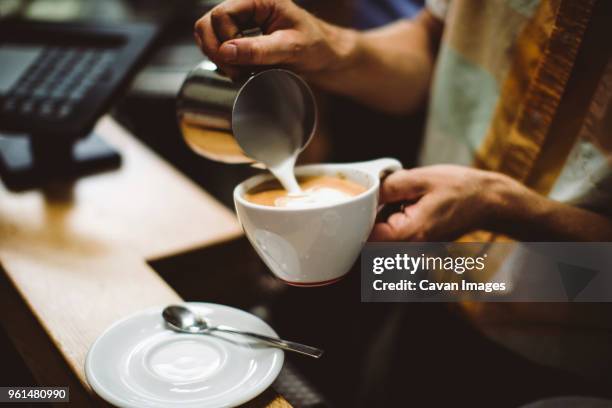 midsection of barista making coffee at cafe - barista coffee milk stock pictures, royalty-free photos & images