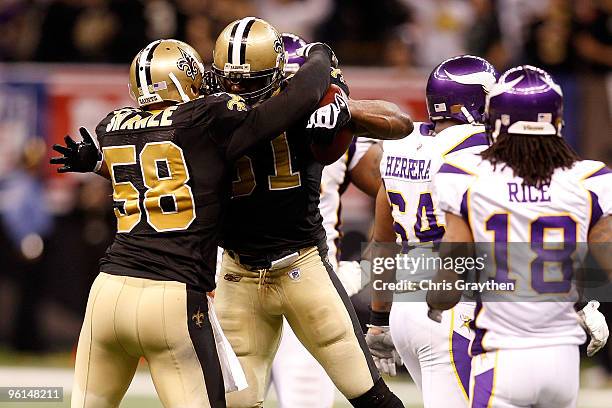 Jonathan Vilma and Scott Shanle of the New Orleans Saints celebrate a defensive stop in the second quarter against the Minnesota Vikings during the...