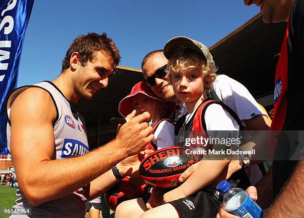 Jobe Watson captain of the Bombers signs autographs for fans during an Essendon Bombers AFL training session at Windy Hill on January 25, 2010 in...