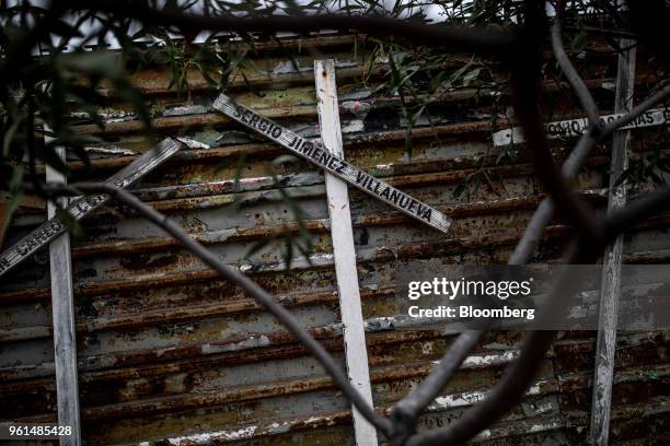 Crosses with the names of people killed trying to cross into the United States hang on a border fence in Tijuana, Mexico, on Monday, May 21, 2018....