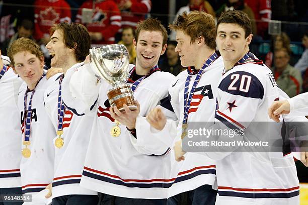 Jack Campbell of Team USA passes the 2010 IIHF Champions Cup to Jake Gardiner of Team USA during the 2010 IIHF World Junior Championship Tournament...