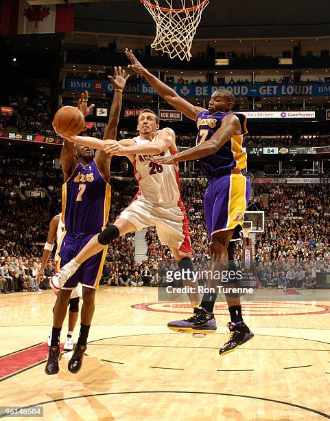 Hedo Turkoglu of the Toronto Raptors drives the paint and splits defenders Lamar Odom and Andrew Bynum of the Los Angeles Lakers during a game on...