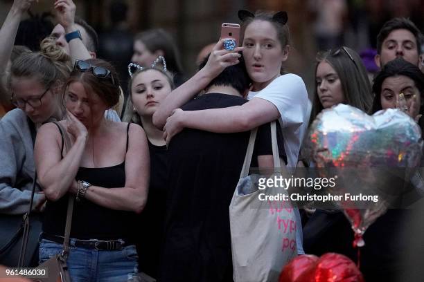 People pause for thought near floral tributes, in St Ann's Square on the first anniversary of the Manchester terrorist attack on May 22, 2018 in...