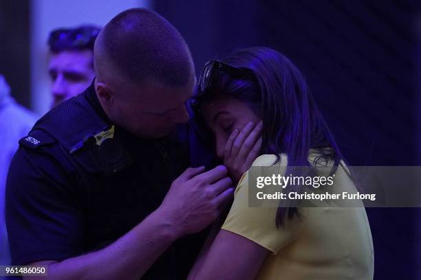 An off duty police officer consoles his girlfriend in St Ann's Square on the first anniversary of the Manchester terrorist attack on May 22, 2018 in...