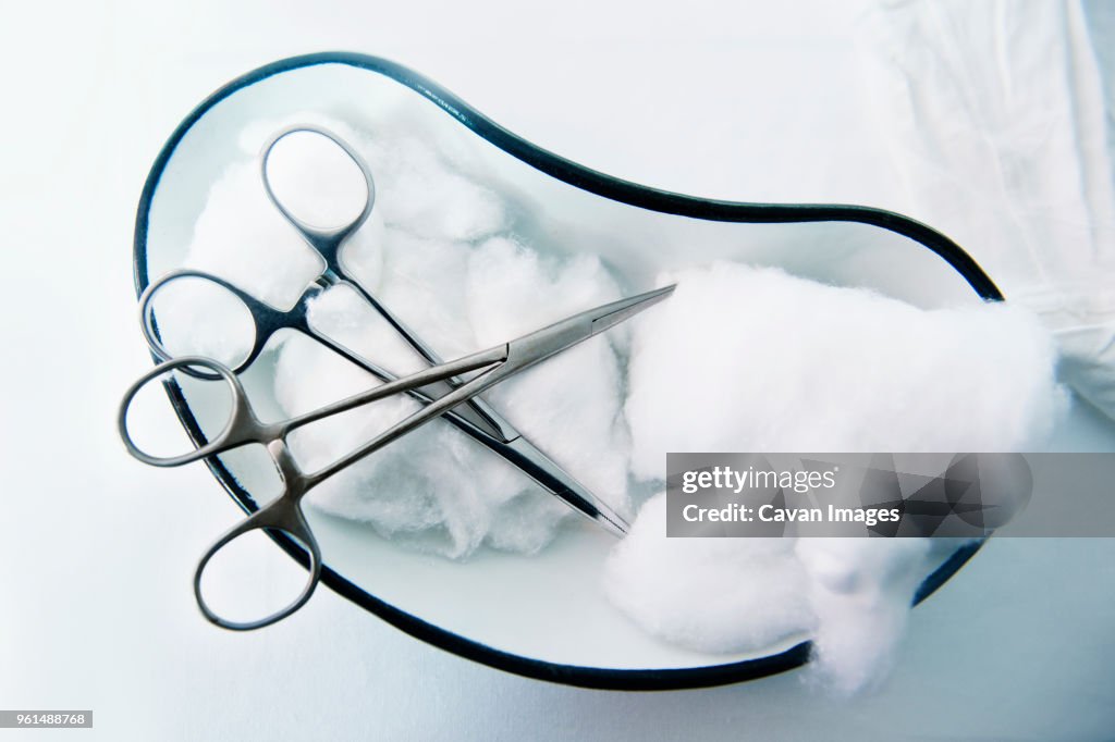 Overhead view of scissors and cotton on table in hospital