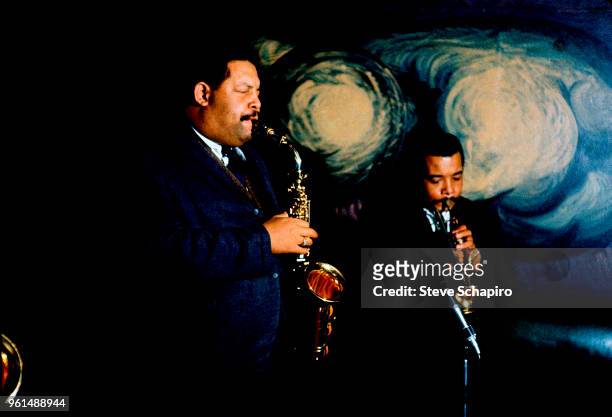 American brothers and Jazz musicians Julian Cannonball Adderley , on saxophone, and Nat Adderley , on cornet, perform together onstage at the Village...