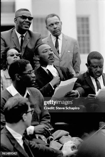 View of American religious and Civil Rights leader Dr Martin Luther King Jr , among other dignitaries, as he sits in front of the Montgomery State...