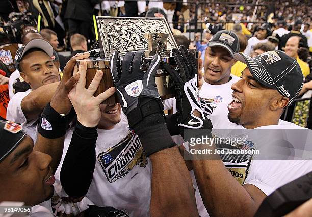 Darren Sharper and Garrett Hartley of the New Orleans Saints celebrate with the NFC Championship trophy after defeating the Minnesota Vikings to win...