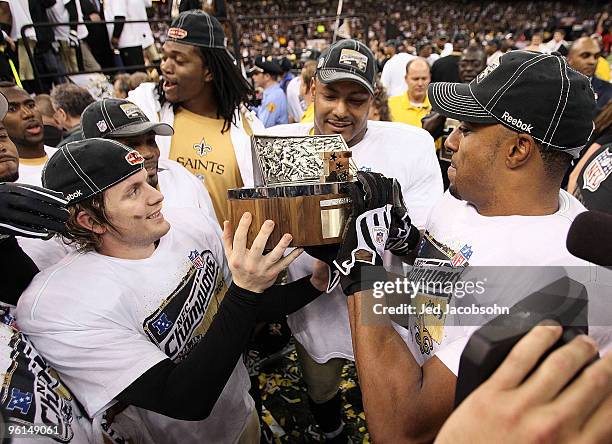 Darren Sharper and Garrett Hartley of the New Orleans Saints celebrate with the NFC Championship trophy after defeating the Minnesota Vikings to win...