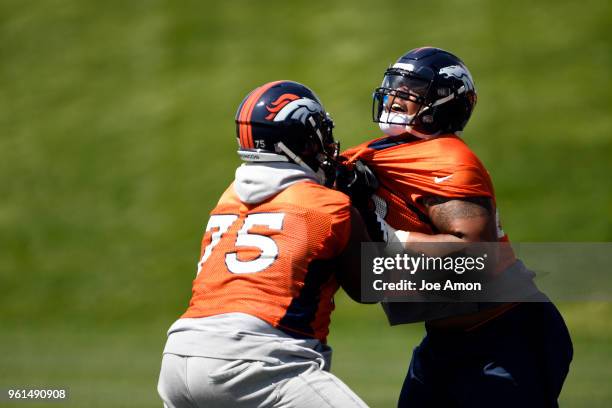 Denver Broncos offensive tackle Menelik Watson drives offensive tackle Elijah Wilkinson on the first day of Broncos OTA's at the UCHealth Training...