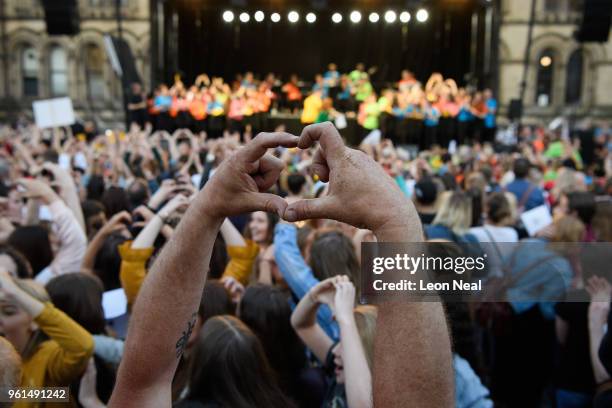 People make the heart symbol with their fingers during the 'Manchester Together - With One Voice' Arena Bombing tribute concert at Albert Square, on...