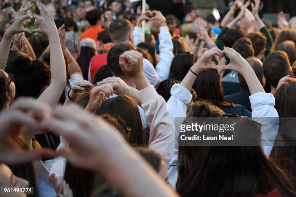 People make the heart symbol with their fingers during the 'Manchester Together - With One Voice' Arena Bombing tribute concert at Albert Square, on...