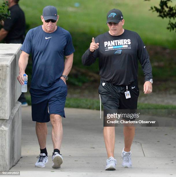 Carolina Panthers head coach Ron Rivera, right, walks with former Dallas Cowboys quarterback and NFL Hall of Fame member Troy Aikman on their way to...
