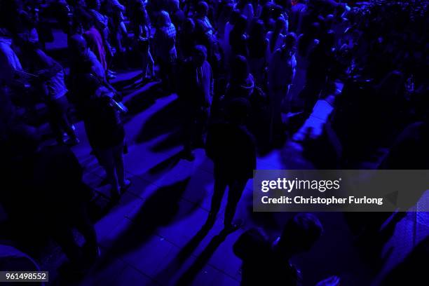 People are illuminated by blue light as they stand in silence in St Ann's Square at 2231, the exact time the Manchester attacker detonated his bomb...