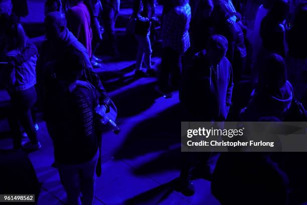 People are illuminated by blue light as they stand in silence in St Ann's Square at 2231, the exact time the Manchester attacker detonated his bomb...