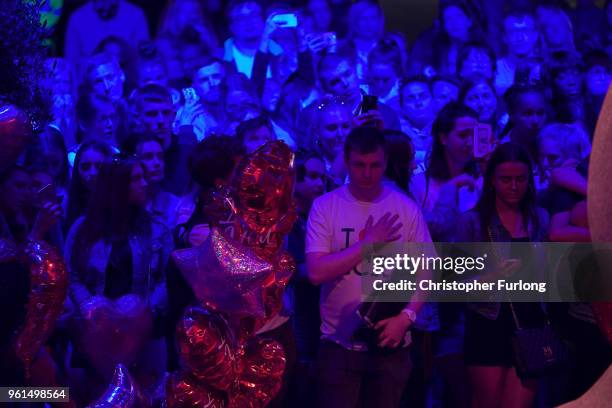 People are illuminated by blue light as they stand in silence in St Ann's Square at 2231, the exact time the Manchester attacker detonated his bomb...