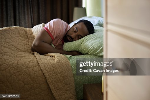 Man sleeping on bed at home Man sleeping on bed at home