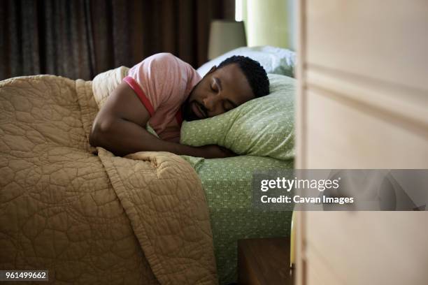 man sleeping on bed at home - black man sleeping in bed stock pictures, royalty-free photos & images