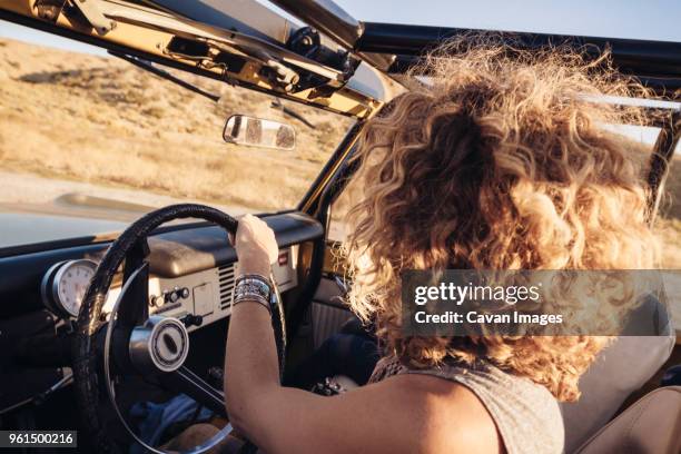 side view of woman with curly hair driving off-road vehicle - messy car interior stock pictures, royalty-free photos & images