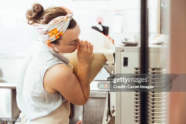 woman pouring ingredients in ice cream maker at commercial kitchen - ice cream maker stock pictures, royalty-free photos & images
