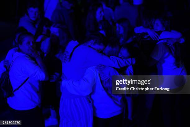 People are illuminated by blue light as they stand in silence in St Ann's Square at 2231 the exact time the Manchester attacker detonated his bomb...