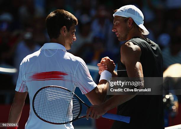 Novak Djokovic of Serbia and Lukasz Kubot of Poland embrace at the net after their fourth round match during day eight of the 2010 Australian Open at...