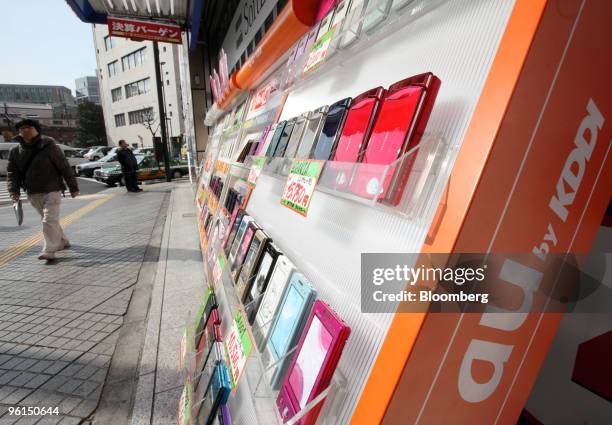 Various models of KDDI Corp. Mobile phones are displayed outside an electronics store in Tokyo, Japan, on Monday, Jan. 25, 2010. KDDI Corp., Japan's...