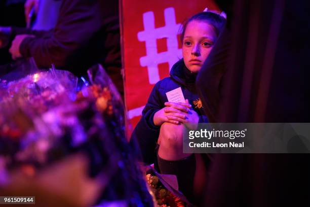 Young girl sits among the visitors in St Anne's Square during a silence held at 22:31, exactly one year after the bomb detonated, on the first...