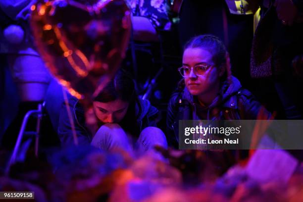 Two young women sit among the floral tributes and balloons exactly one year after the bomb detonated, on the first anniversary of the terrorist...