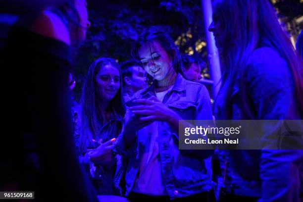 Group of young women look at a mobile phone screen in St Anne's Square ahead of a silence held at 22:31, exactly one year after the bomb detonated,...