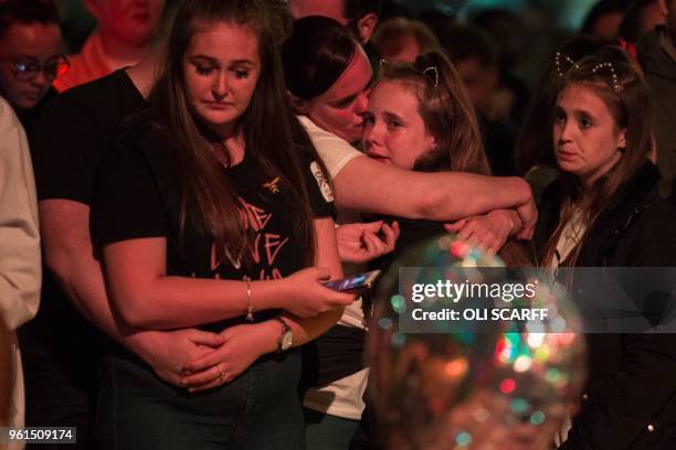 People grieve during a silence at 10:31pm, the exact one year anniversary of the deadly attack at Manchester Arena, central Manchester on May 22,...