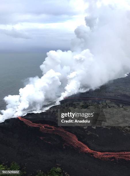 Ash plume rises from forest following a massive volcano eruption on Kilauea volcano in Hawaii, United States on May 22, 2018. Lava is spewing more...