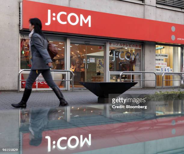 Pedestrian walks past Jupiter Telecommunications Co.'s J:COM shop in Tokyo, Japan, on Monday, Jan. 25, 2010. KDDI Corp., Japan's second-biggest...