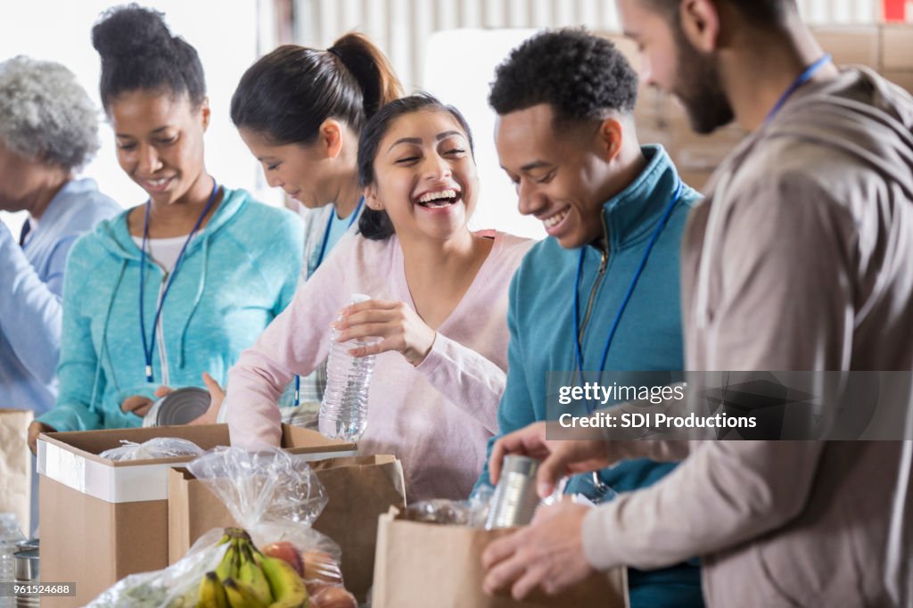 Voluntaria de la feliz pareja en Banco de alimentos de la comunidad