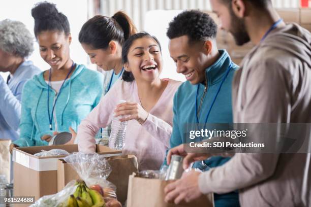 happy couple volunteer in community food bank - food donation stock pictures, royalty-free photos & images