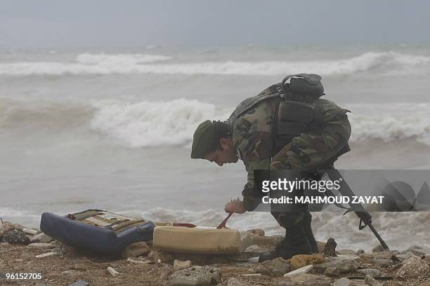 Lebanese army soldier inspects the debris of an Ethiopian Boeing 737 that crashed off the Lebanese coast, south of the capital Beirut, on January 25,...
