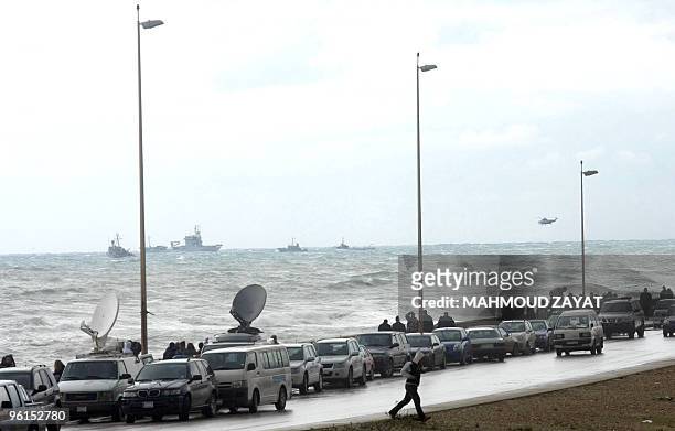 Lebanese army helicopters and United Nations vessels scan the sea off the Lebanese coast as members of the press corps and onlookers gather on the...