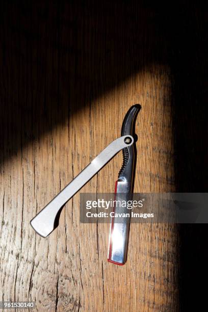 overhead view of straight razor on wooden table - straight razor stock pictures, royalty-free photos & images