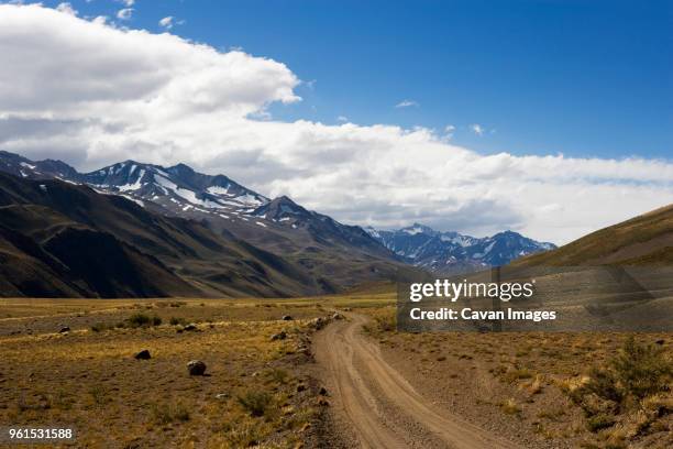 scenic view of landscape against cloudy sky - argentina dirt road panorama stock pictures, royalty-free photos & images