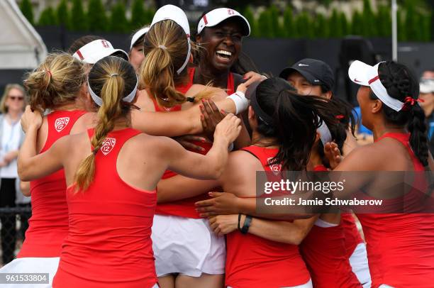 Teammates rush Melissa Lord of the Stanford Cardinal after her clinching victory over the Vanderbilt Commodores during the Division I Women's Tennis...