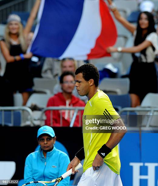 French tennis player Jo-Wilfried Tsonga walks past spectators waving a flag during his fourth round mens singles match against Spanish opponent...