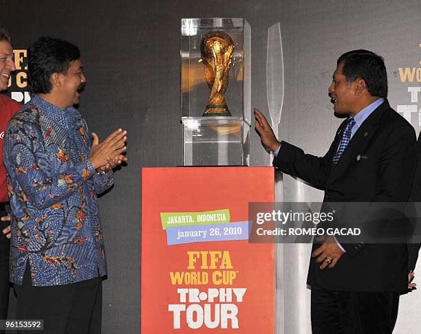 Indonesian Minister of Youth and Sports Andi Mallarangeng and Indonesian Soccer Association chairman Nurdin Halid look at the FIFA World Cup trophy...