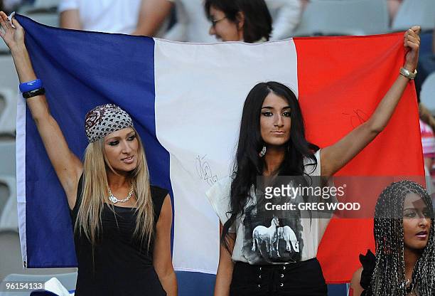 Spectators wave flag as they cheer for French tennis player Jo-Wilfried Tsonga during his fourth round mens singles match against Spanish opponent...
