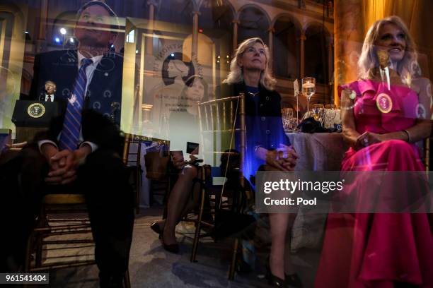 President Donald Trump is reflected in glass as Counselor to the President Kellyanne Conway looks on during the Susan B Anthony List gala at the...