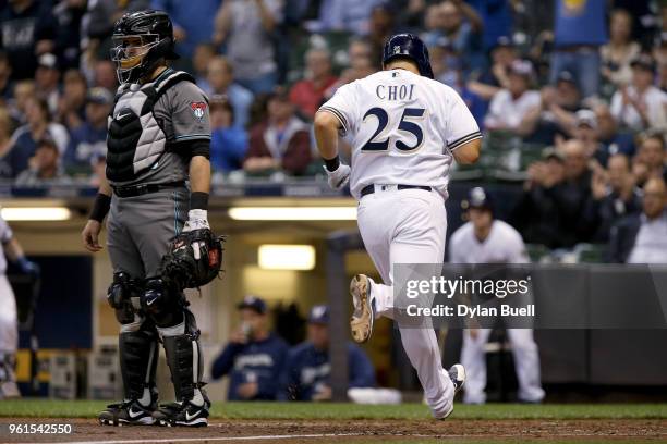 Ji-Man Choi of the Milwaukee Brewers scores a run past Alex Avila of the Arizona Diamondbacks in the sixth inning at Miller Park on May 22, 2018 in...